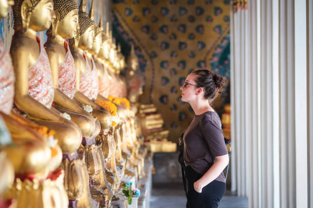 Caucasian tourist woman visiting ancient Buddhist temple in Bangkok, 