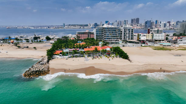 Bright beach stretches along Luanda with clear waters, palm trees, and
